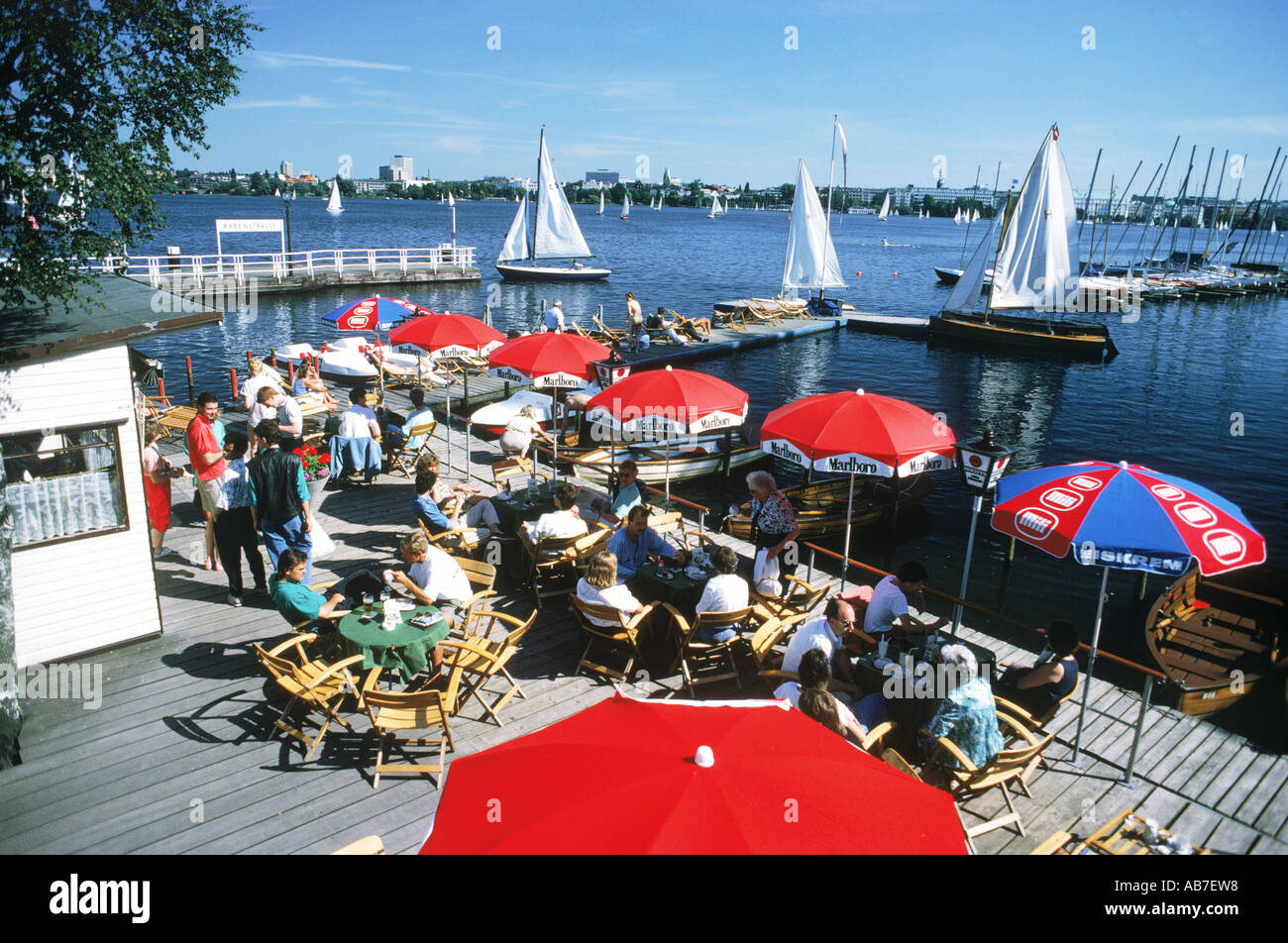 Pier cafe and tables with sailboats on Alster Lake in the middle of Hamburg in Northern Germany Stock Photo