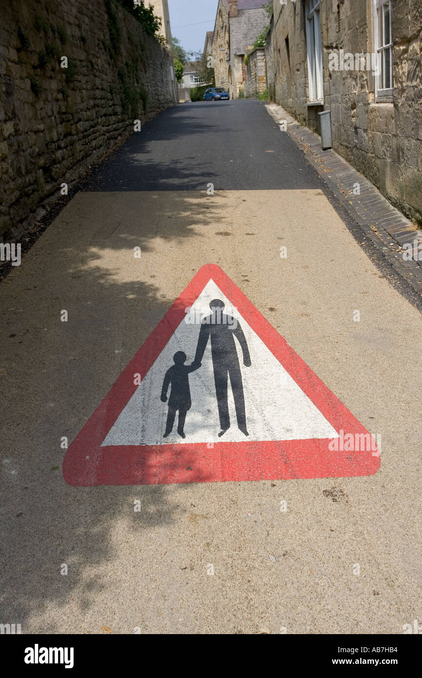 Large road sign on road surface warning motorists of pedestrians Winchcombe Glos UK Stock Photo