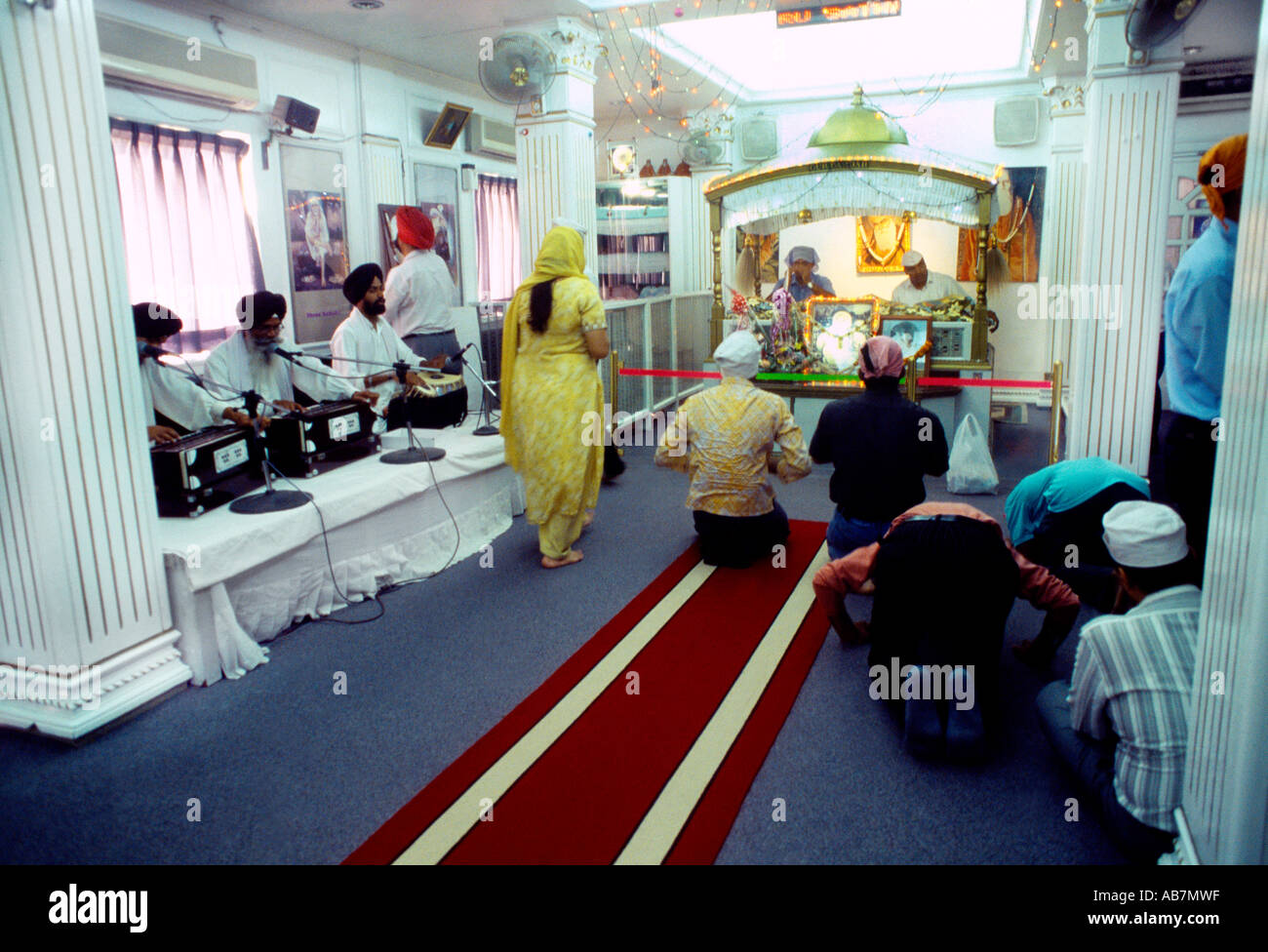 Dubai UAE Sikh Men and Women Bowing Before Guru Granth Sahib in Gurdwara Stock Photo