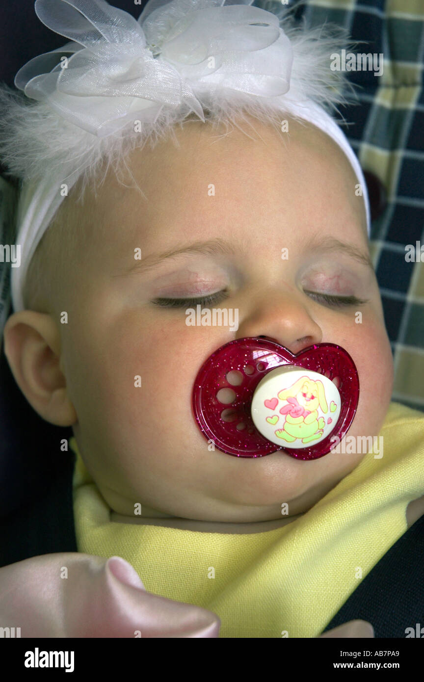 sleeping baby with pacifier and bow Stock Photo