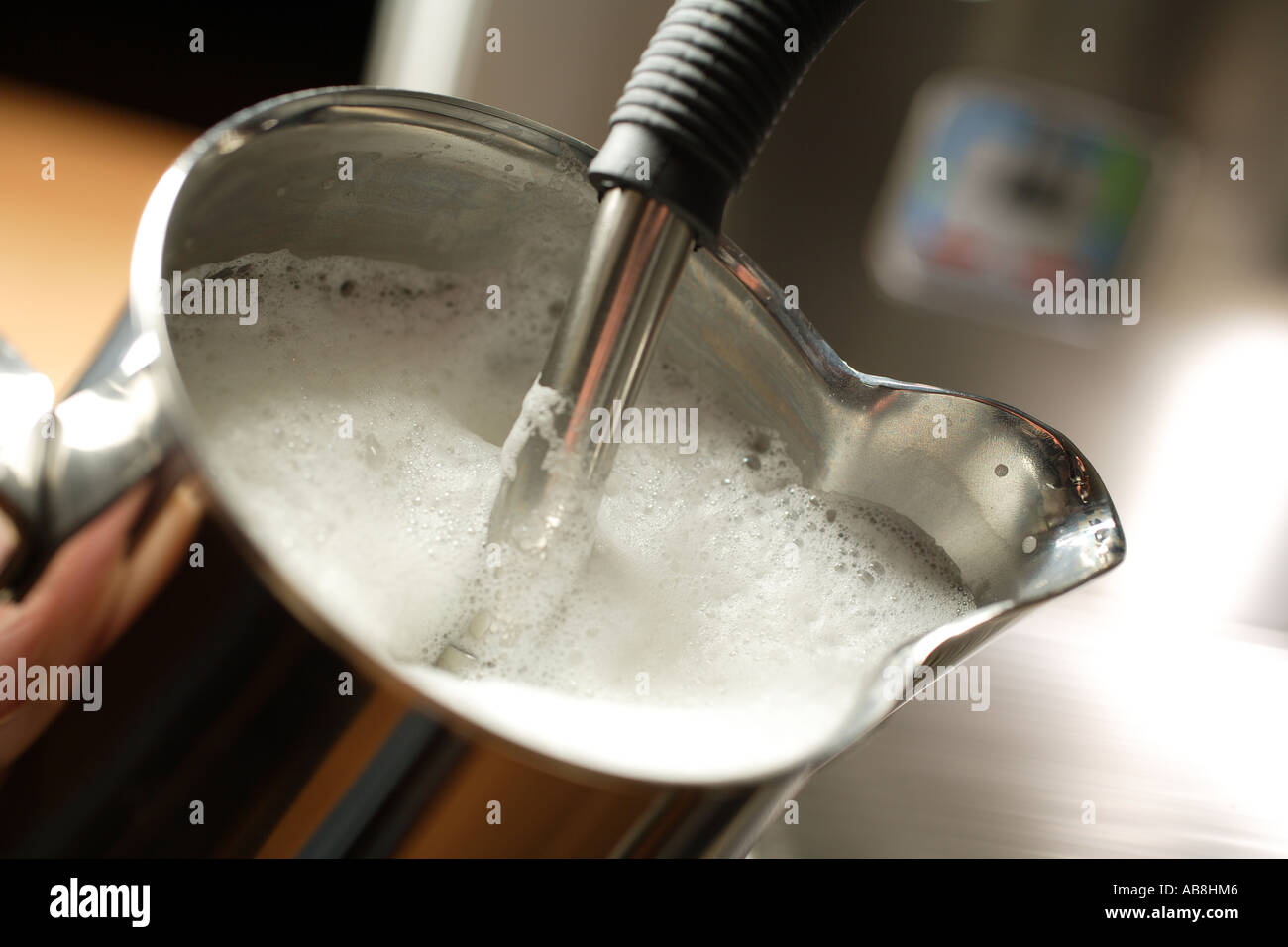 Coffee machine frothing milk in stainless steel jug Stock Photo Alamy
