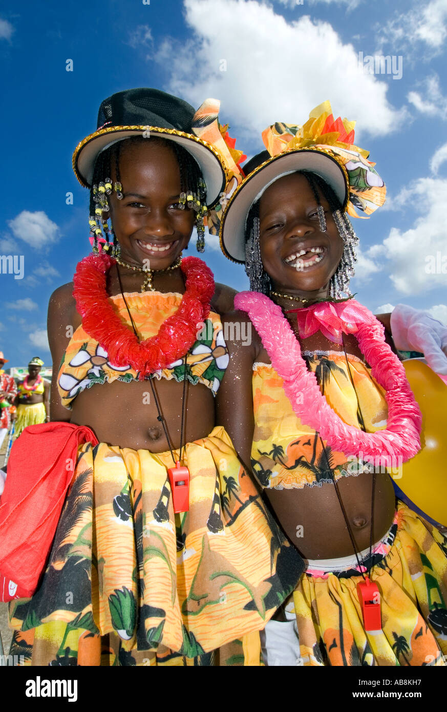 West Indies Trinidad Port of Spain Carnival 2006 Portait of smiling girls in multi colored outfits with blue sky above Stock Photo