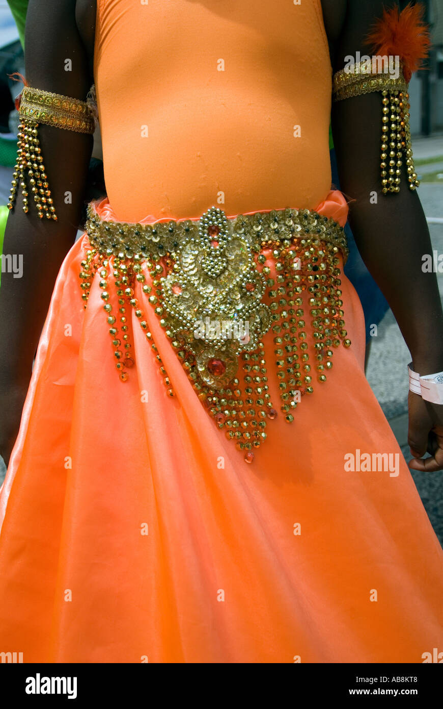 West Indies Trinidad Carnival Port of Spain Colorful orange costume on teen girl dancing in parade Stock Photo