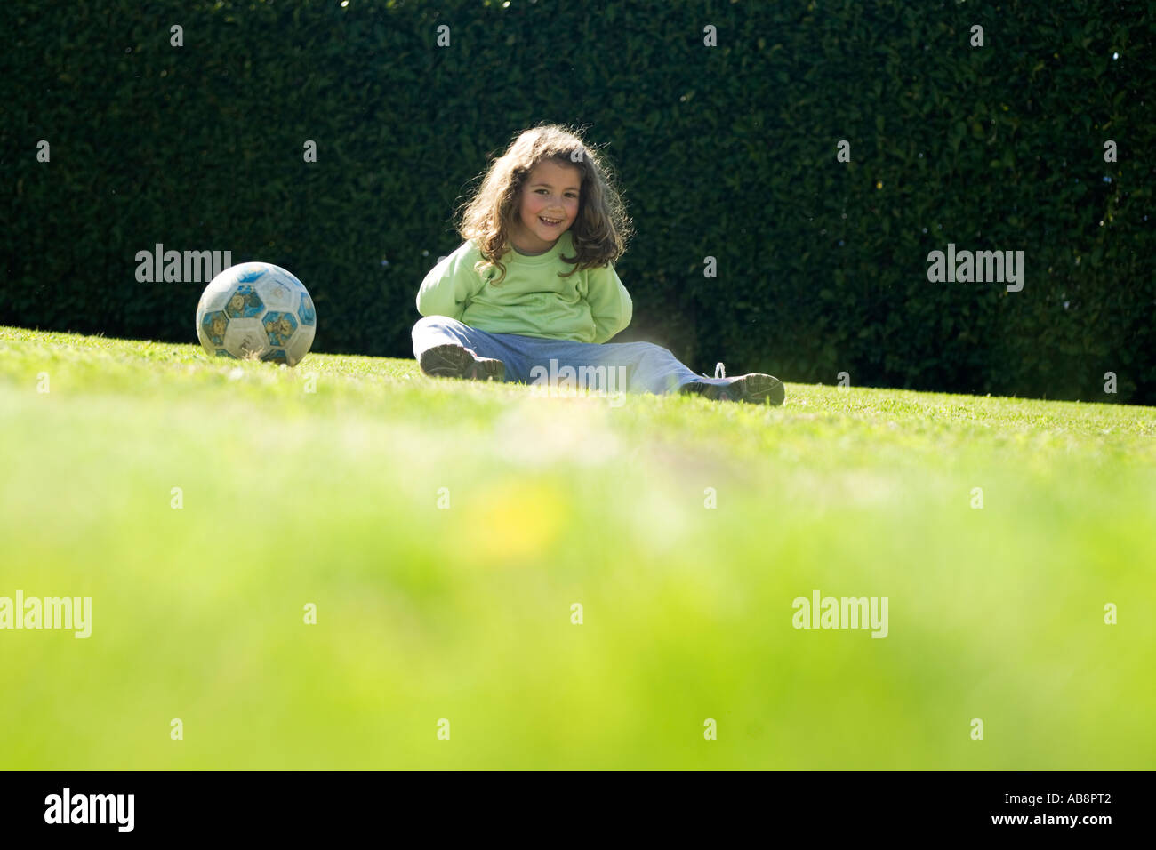 Little girl sitting on the grass with a balloon Stock Photo - Alamy