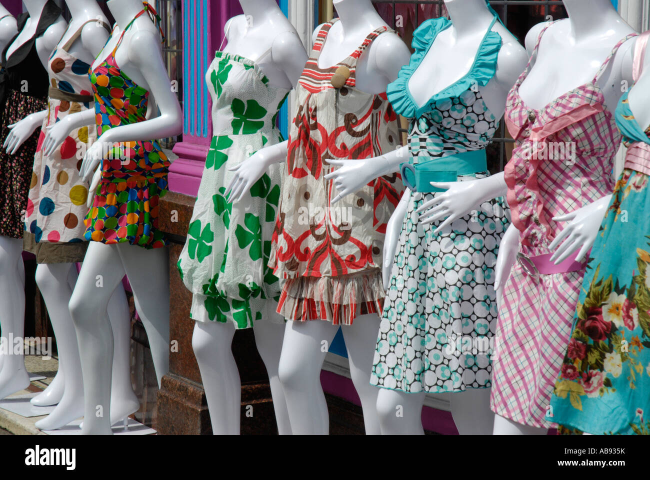 Close up diagonal row of white (female) mannequins wearing colorful short Summer  dresses outside alternative fashion boutique Stock Photo - Alamy