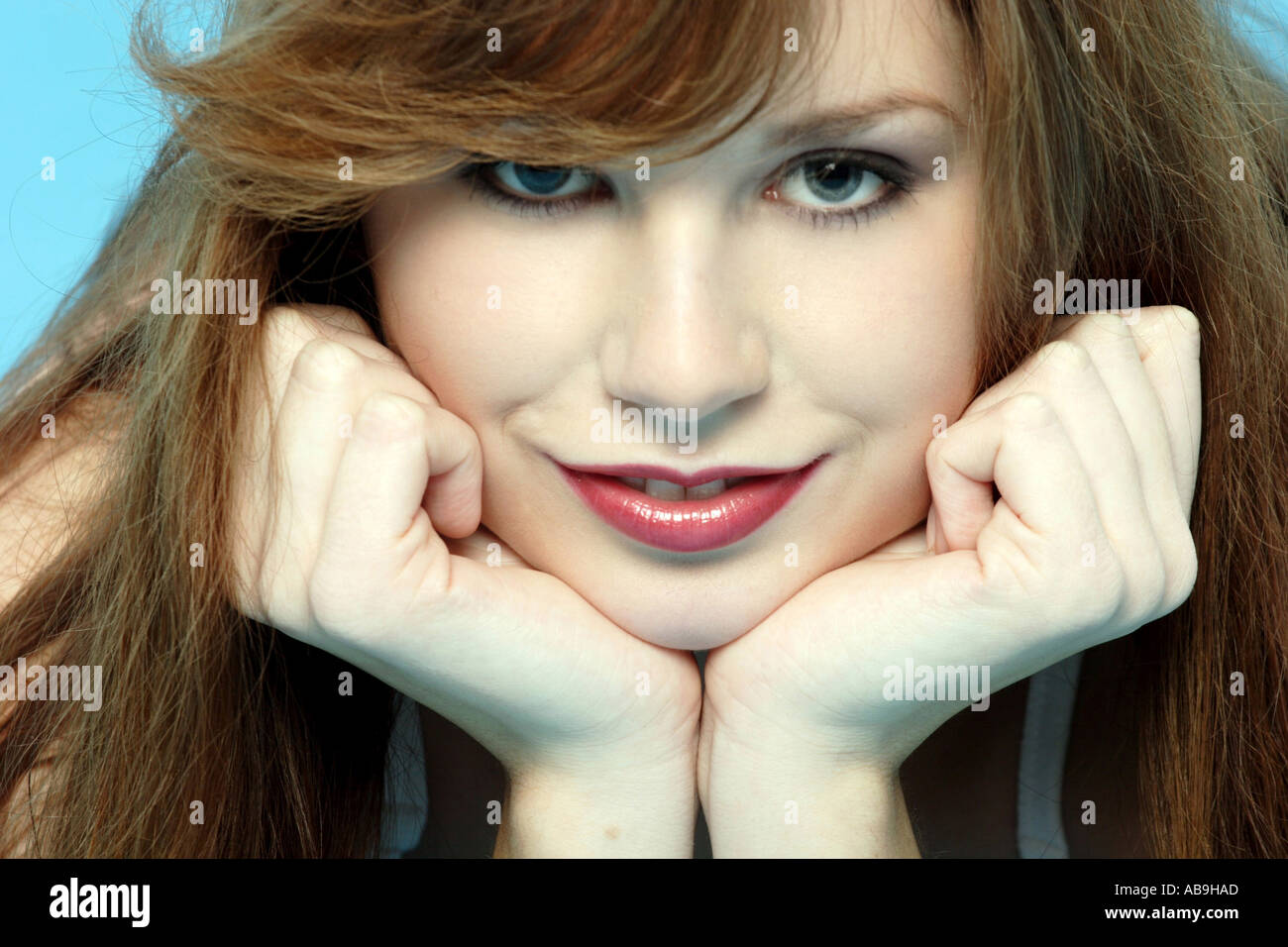 redheaded woman holding chin on her hands. Stock Photo