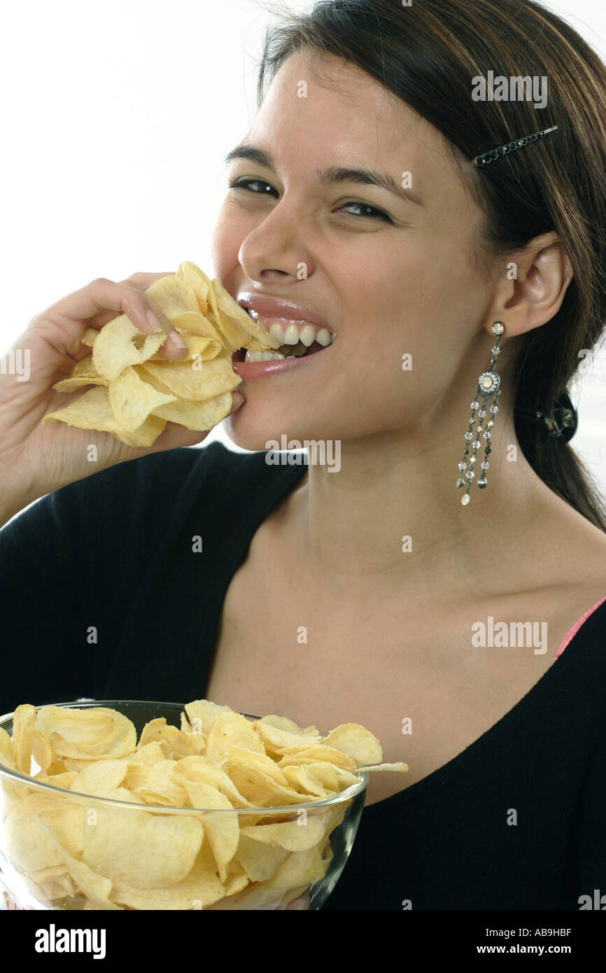 woman dispatching potato chips, having the munchies for potato chips. Stock Photo