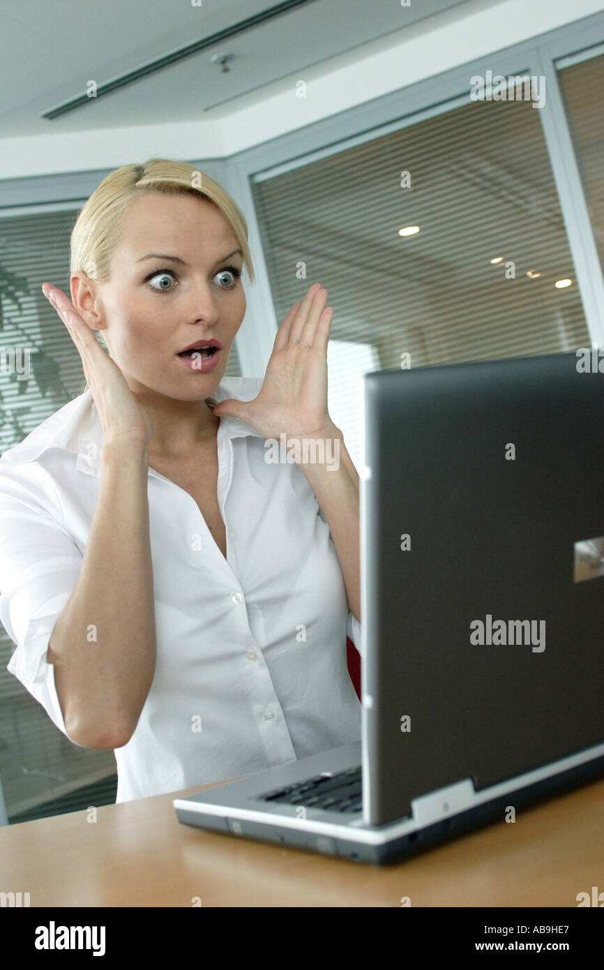 woman looking frightened on laptop. Stock Photo