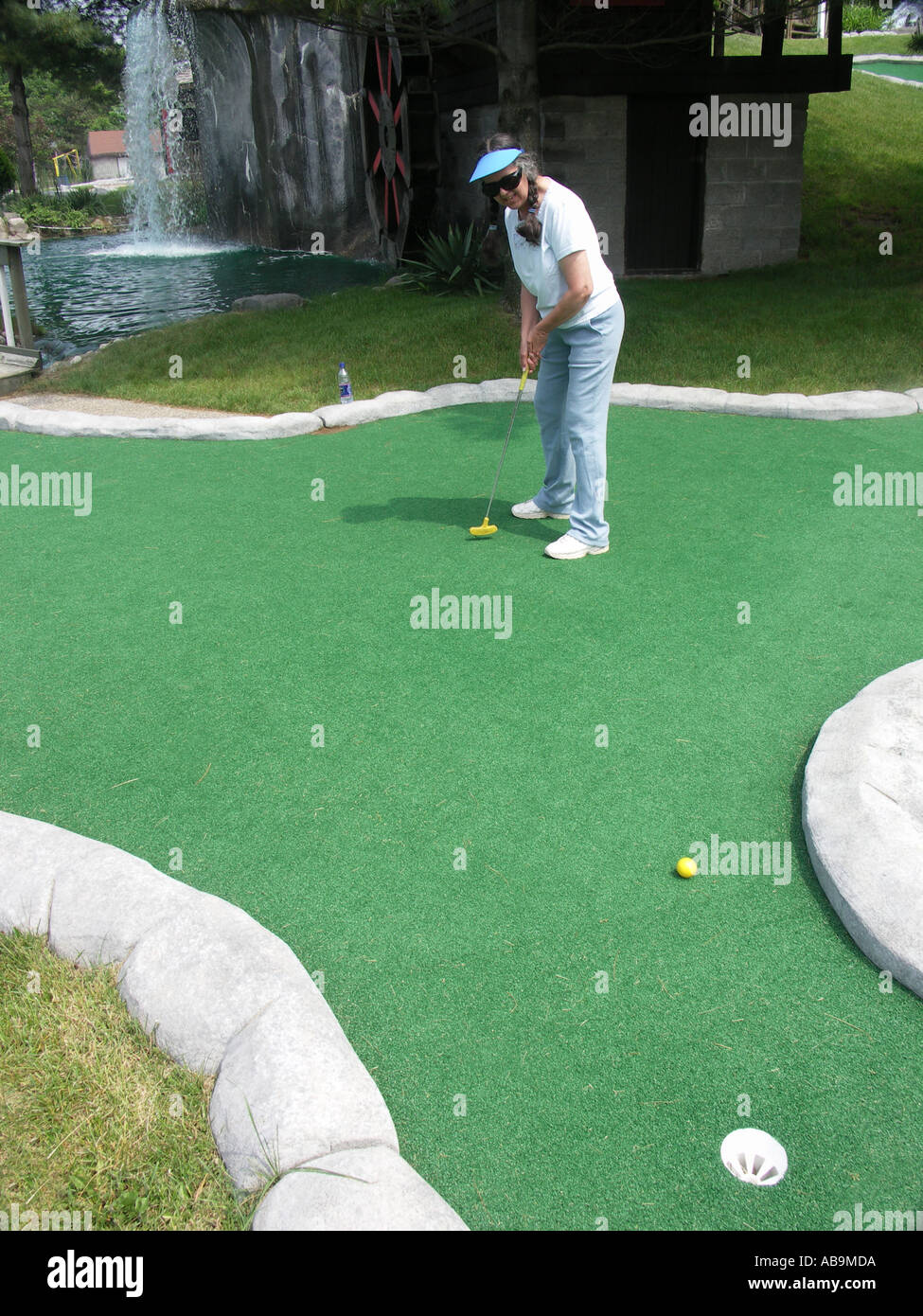 Woman Playing Miniature Golf Stock Photo
