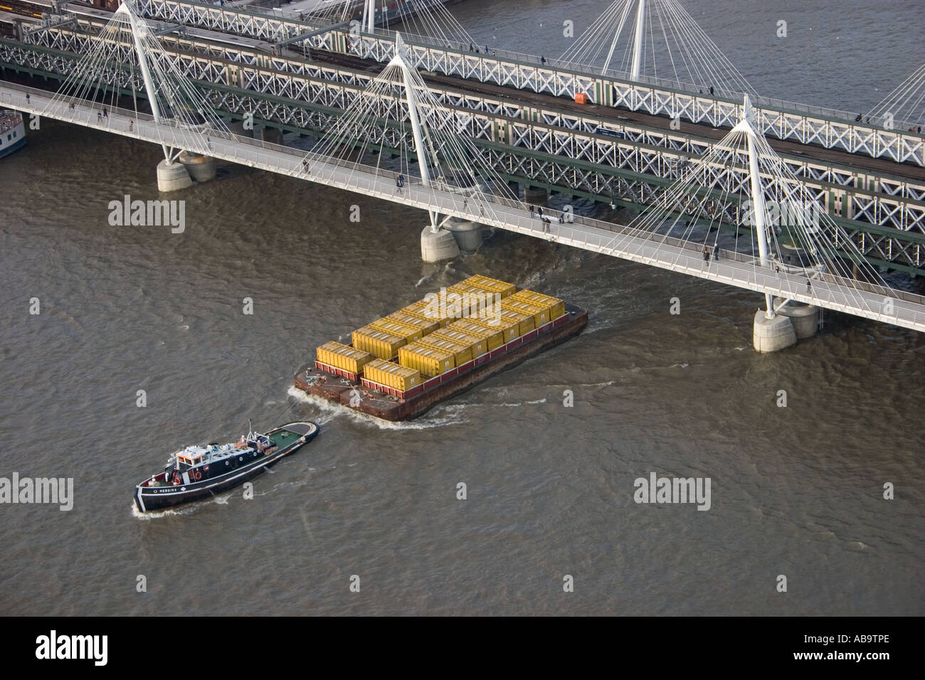 Tugboat pulling raft of containers along the River Thames below the ...