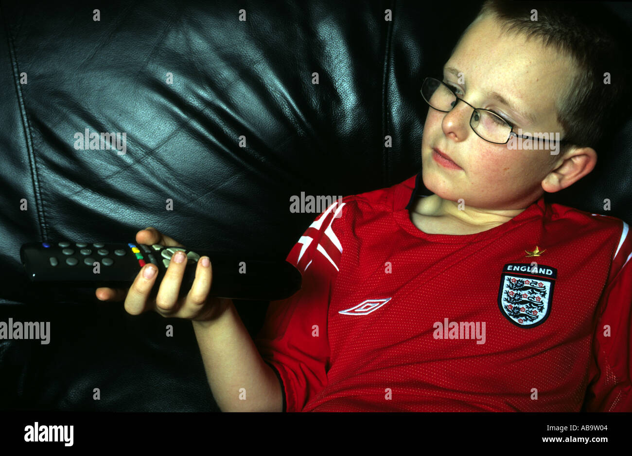 Young England football fan watching a game on television Stock Photo