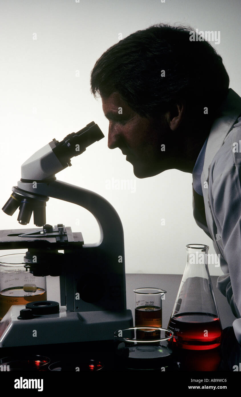 lab technician looking through microscope Stock Photo