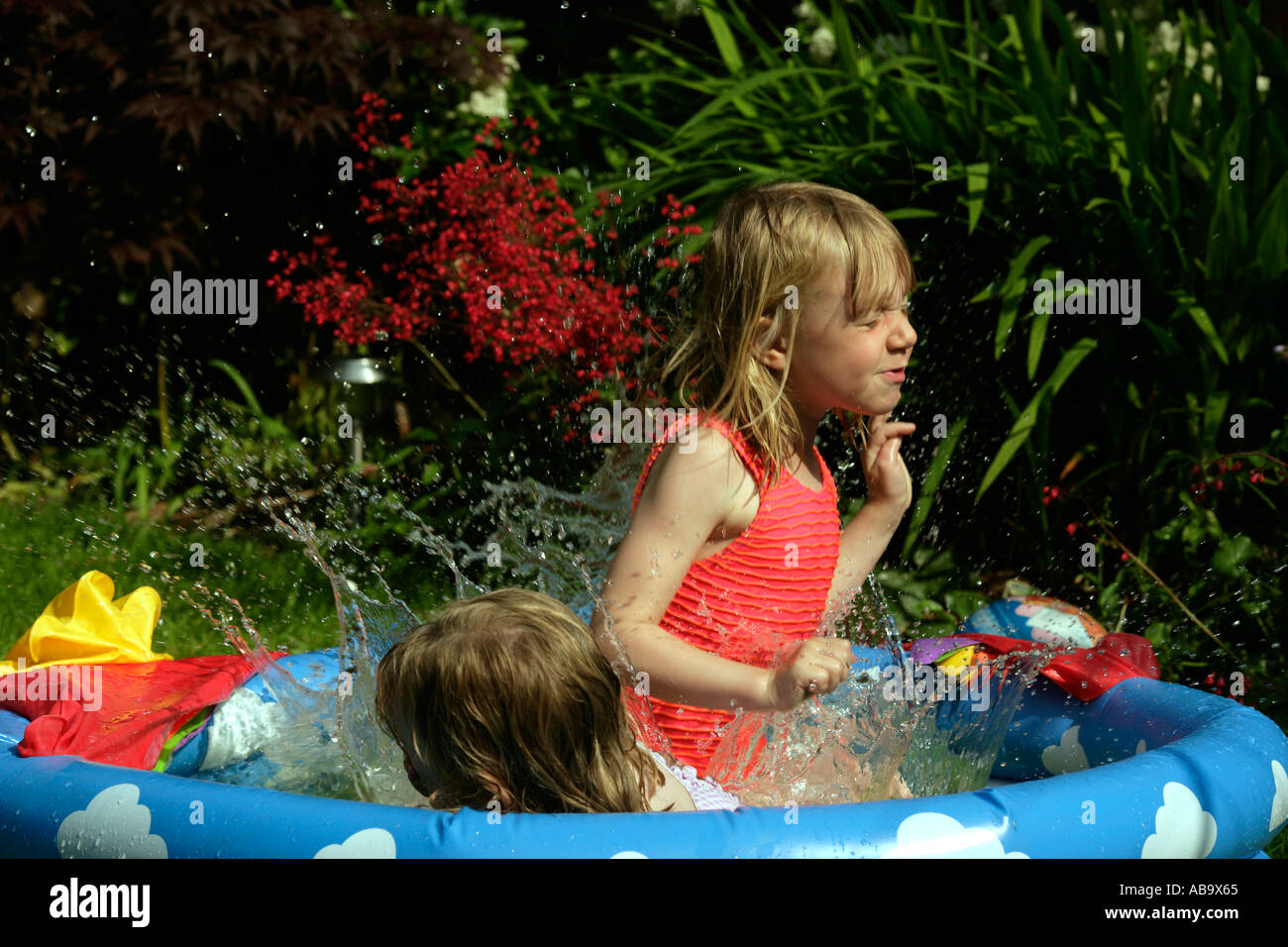 Girls splashing about in a paddling pool Stock Photo Alamy