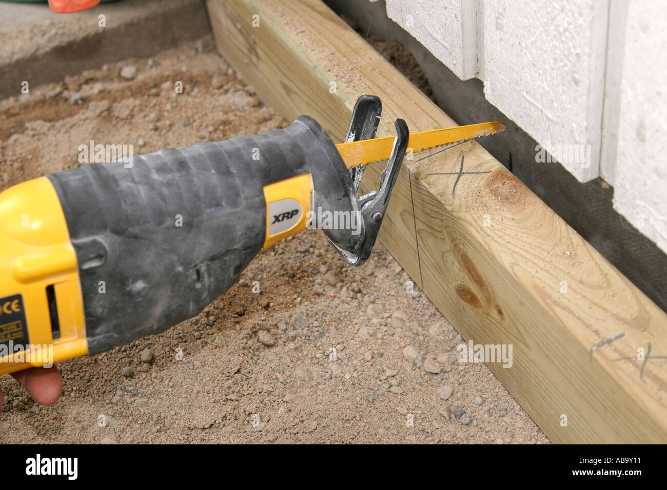 Cutting a plank with a reciprocating saw Stock Photo