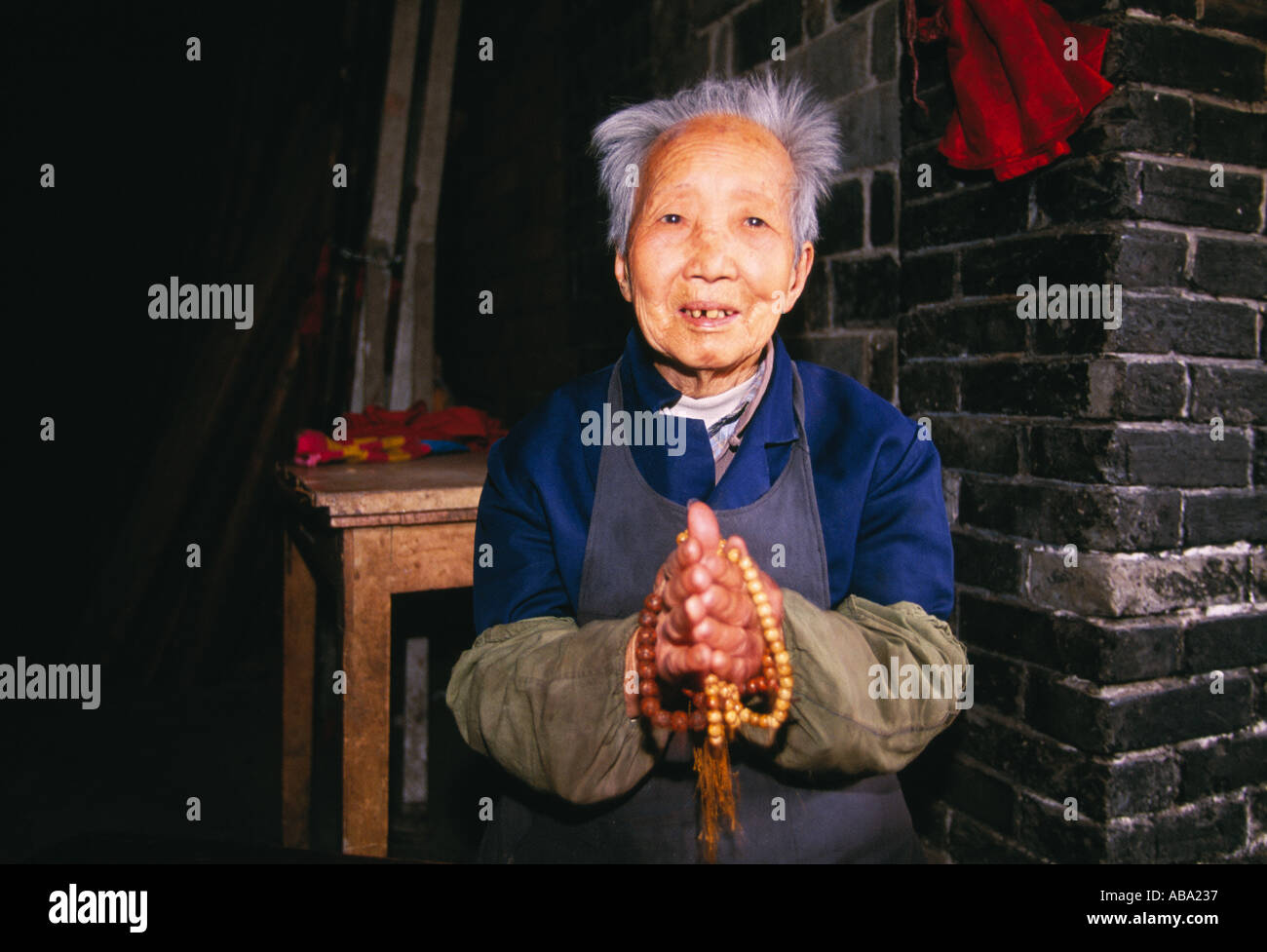 A senior woman holds prayer beads at the Cyunsi Buddhist Nunnery in Chongqing China 041603 Stock Photo