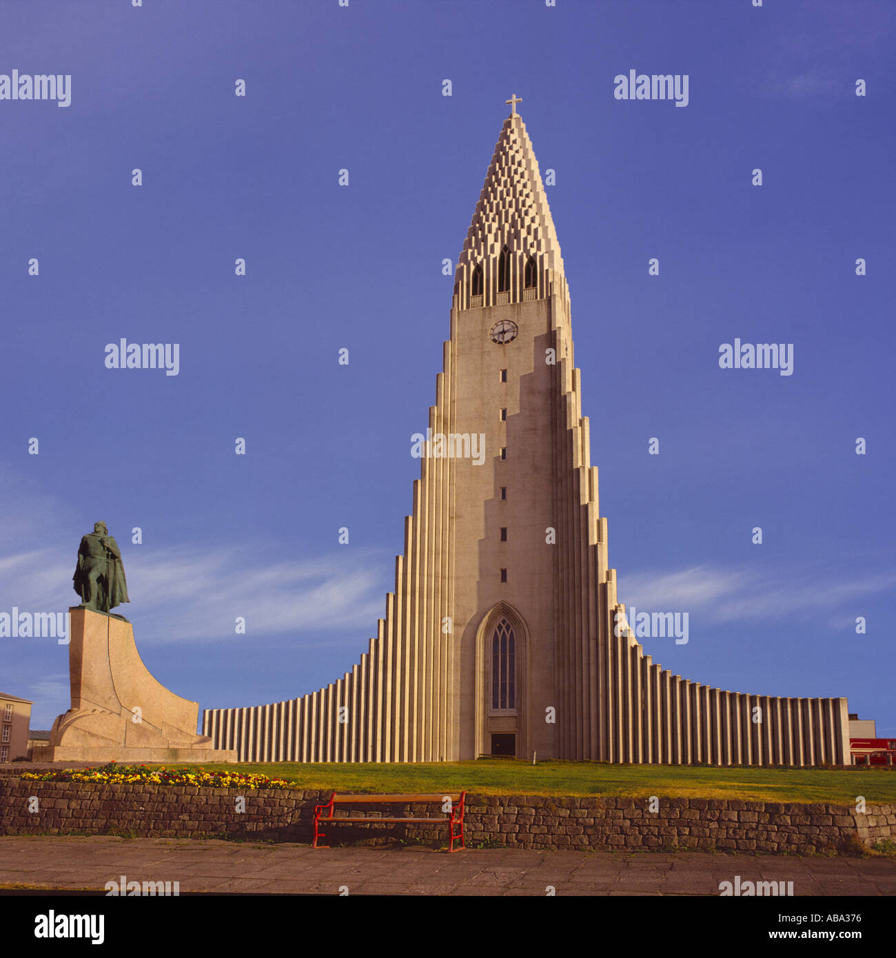 Front on evening sunlit view of Hallgrimurs Church against a blue sky in Reykjavik Iceland Stock Photo