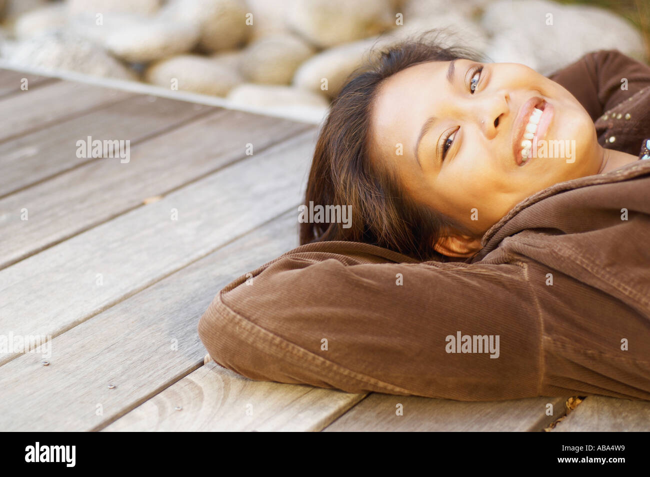 Young woman relaxing on wood deck Stock Photo