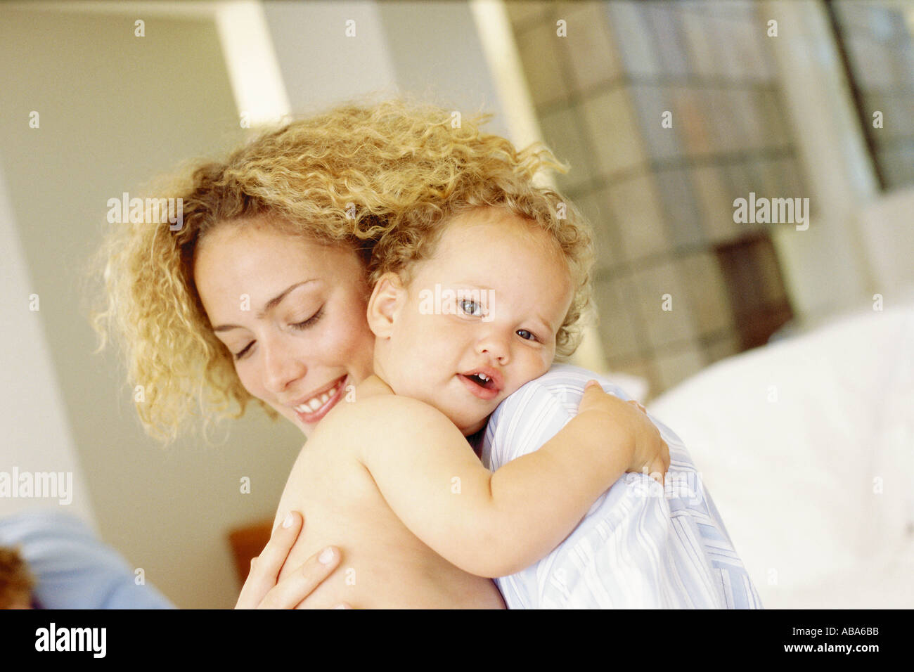 Baby cuddles mother Stock Photo - Alamy