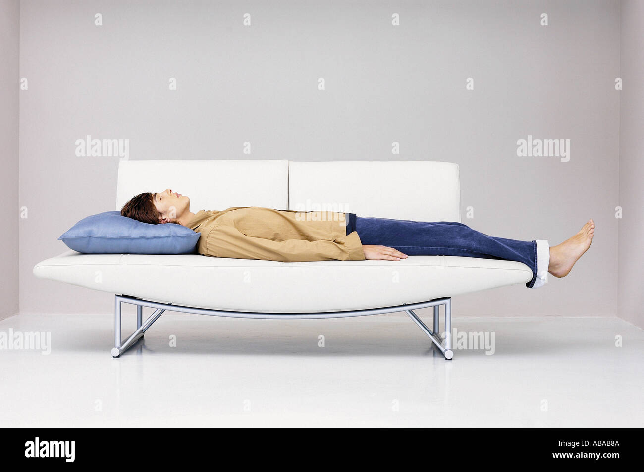 Man lying down on modern sofa Stock Photo