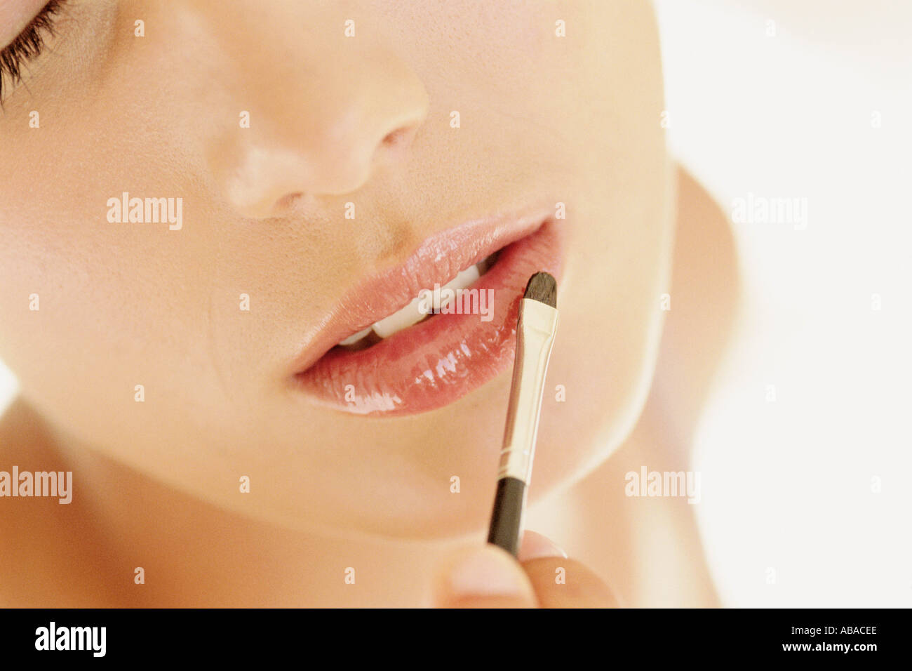 Woman applying lip gloss Stock Photo
