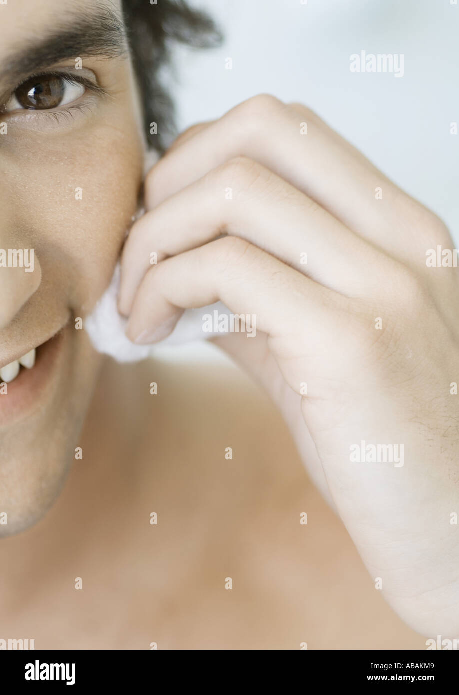 Man rubbing cheek with cotton ball Stock Photo Alamy
