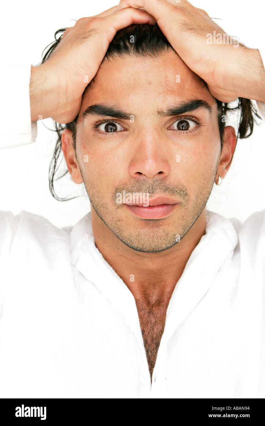 young man with hands on head looking at camera surprised Stock Photo