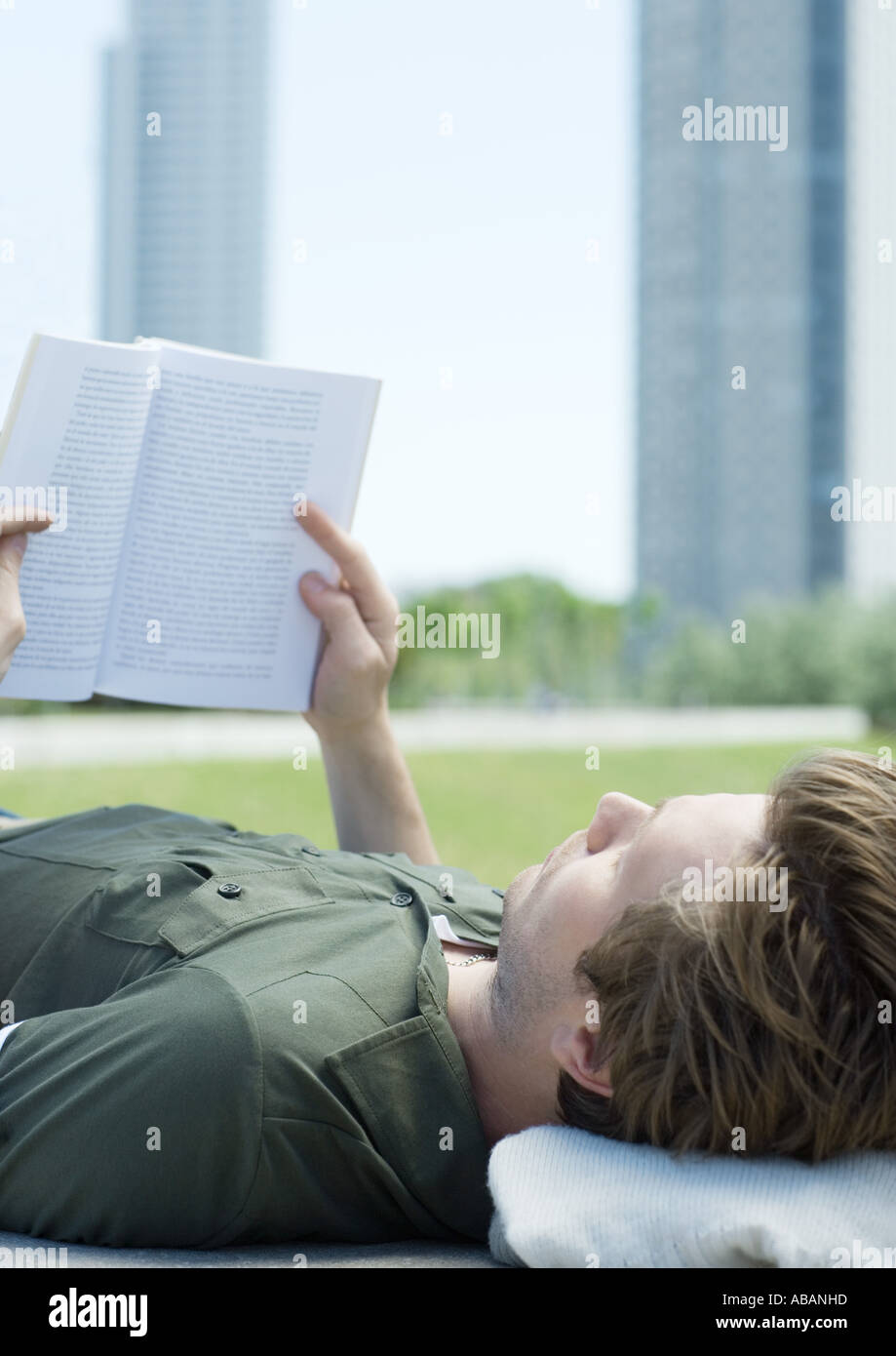 Young man reading in city park, close-up Stock Photo