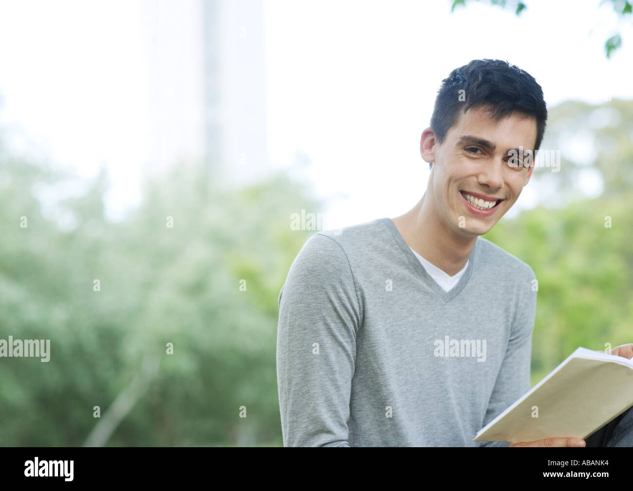 Young man holding book and smiling Stock Photo