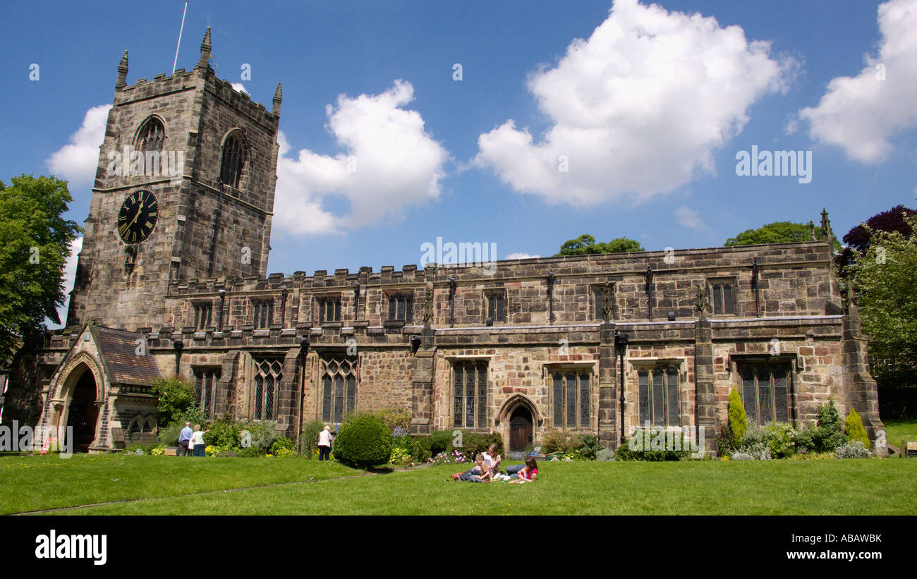 People relaxing on the grass in front the Holy Trinity Church Skipton North Yorkshire Stock Photo