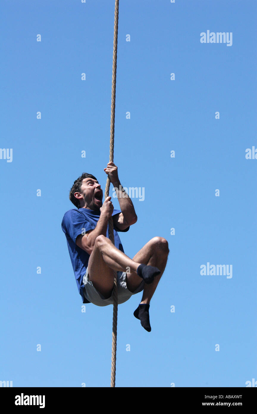 Athlete climbing up the rope Stock Photo