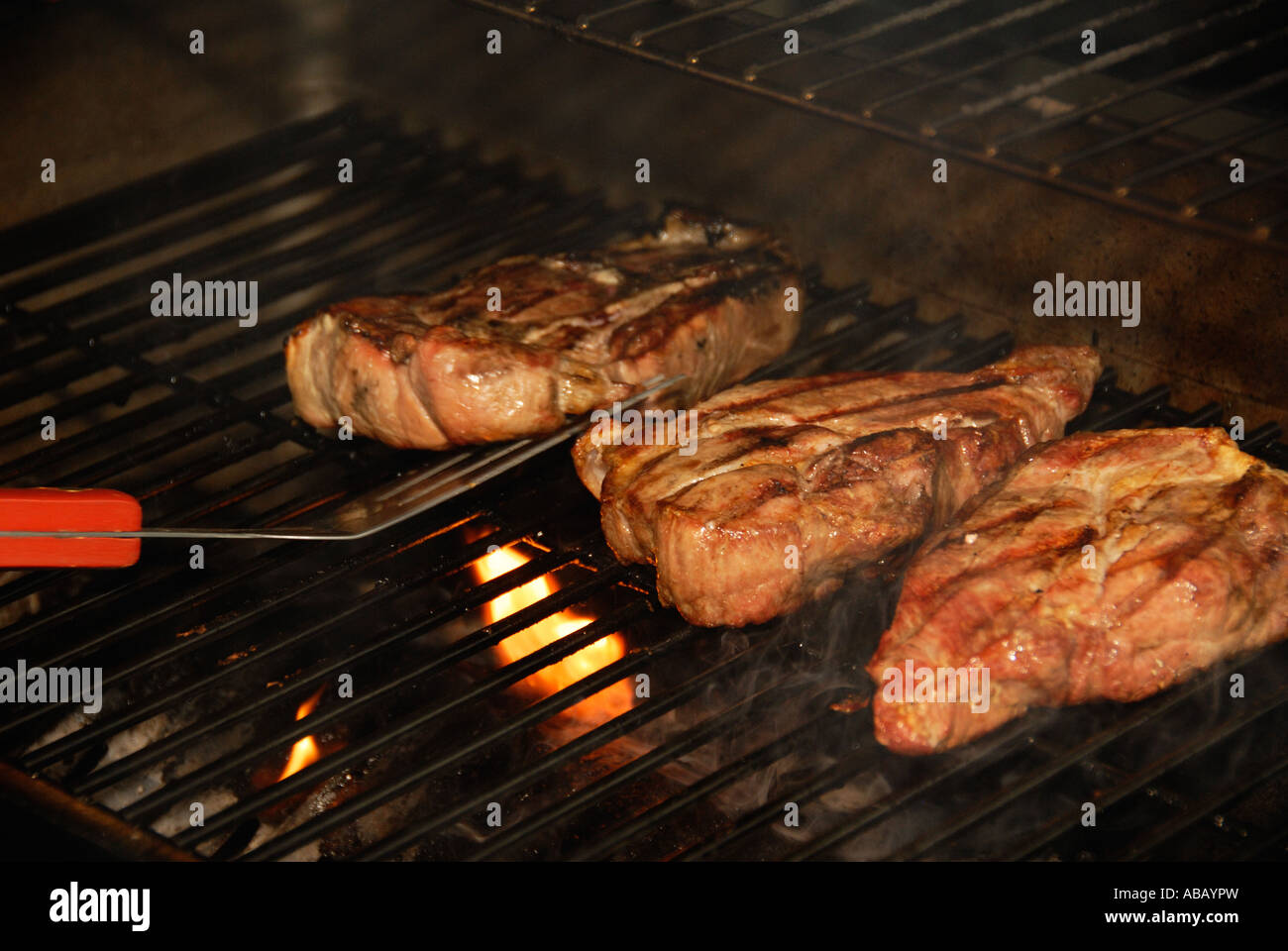 Pork loin steaks cooking on a charcoal grill Stock Photo Alamy