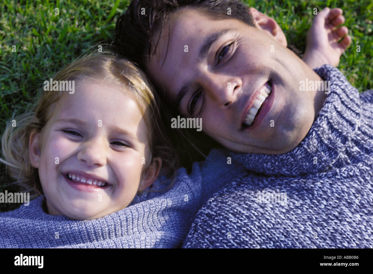Father and daughter lying on grass Stock Photo