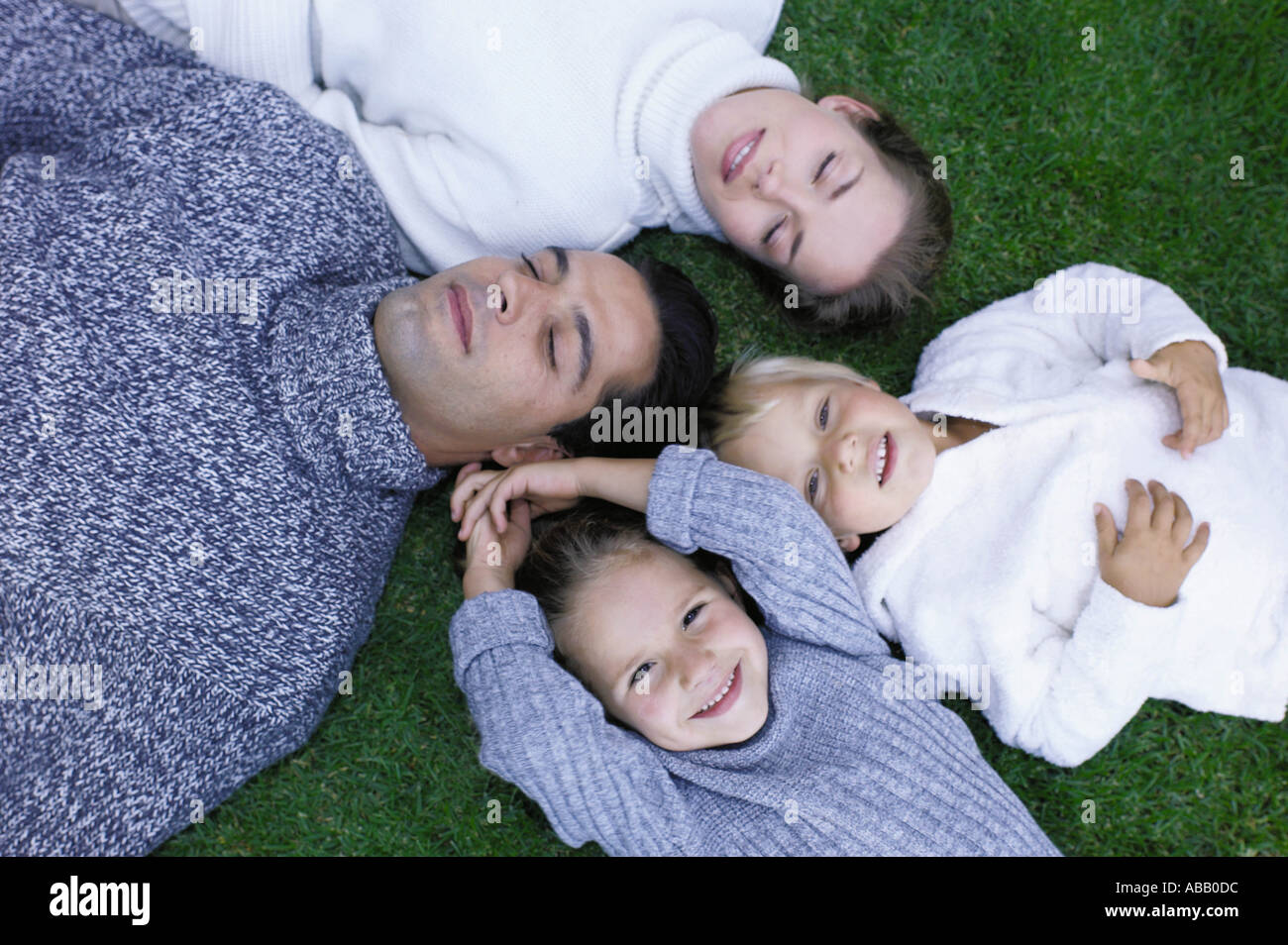 Family lying on the grass Stock Photo