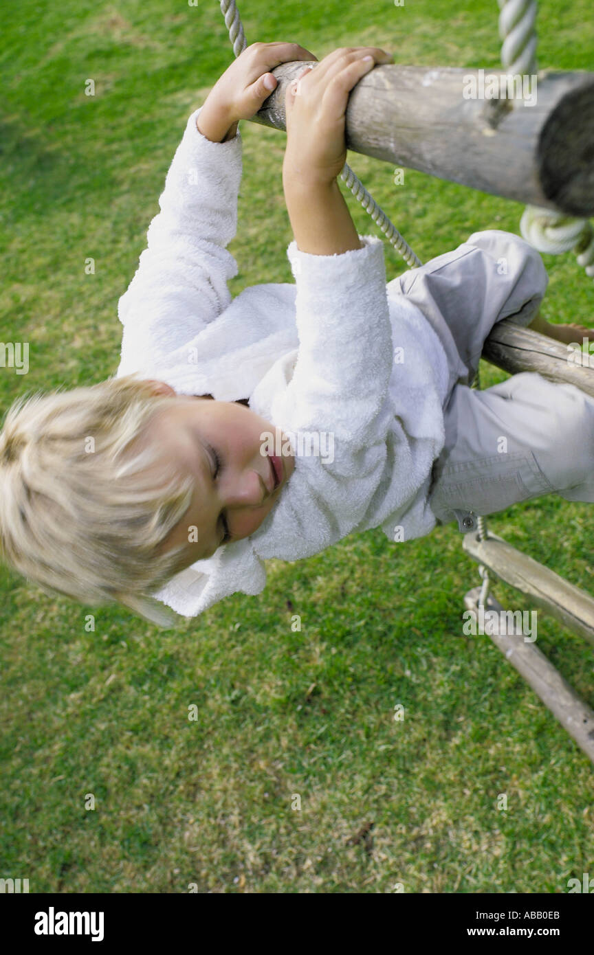 Boy climbing rope ladder Stock Photo Alamy