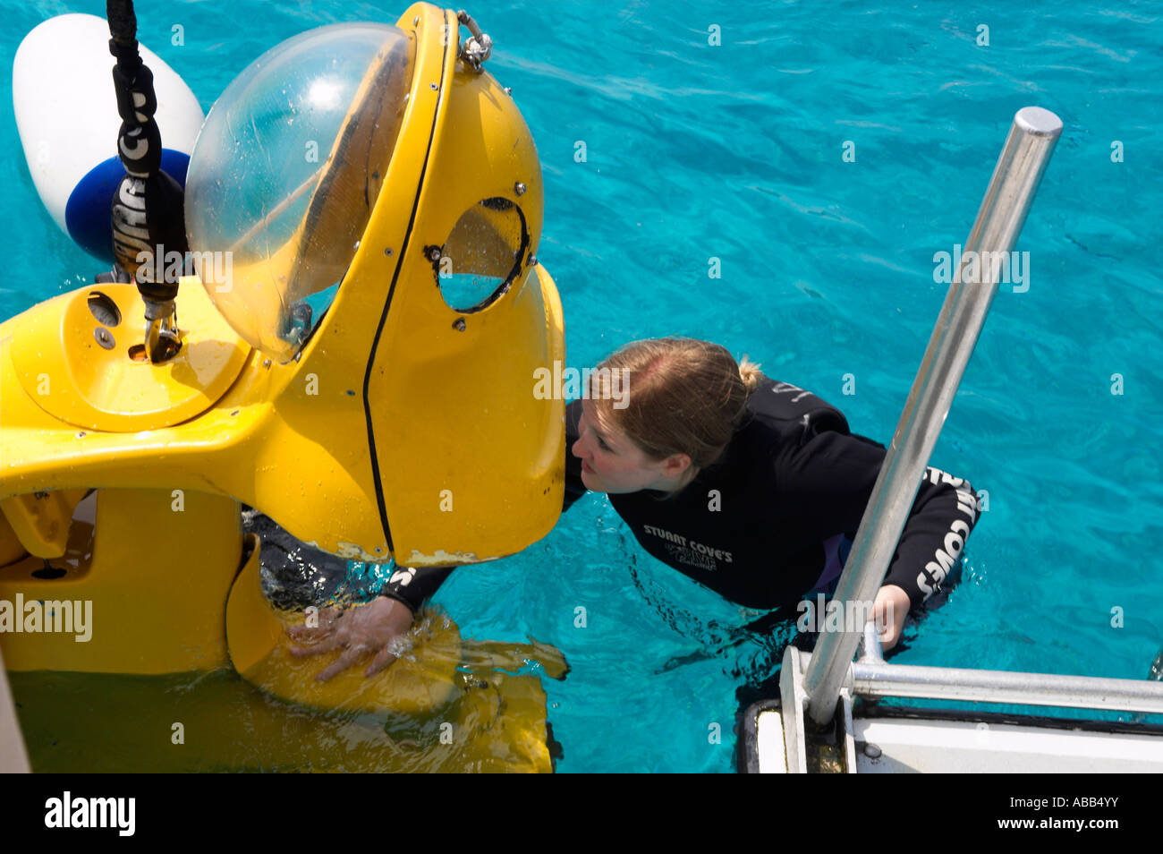 Woman diver entering Yellow Submarines before lowered from boat Stuart Cove s Dive Nassau Paradise Island Bahamas Stock Photo