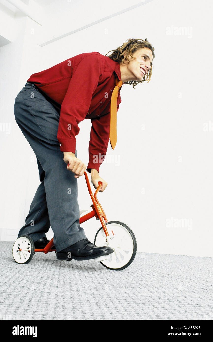 Man riding a small tricycle Stock Photo Alamy