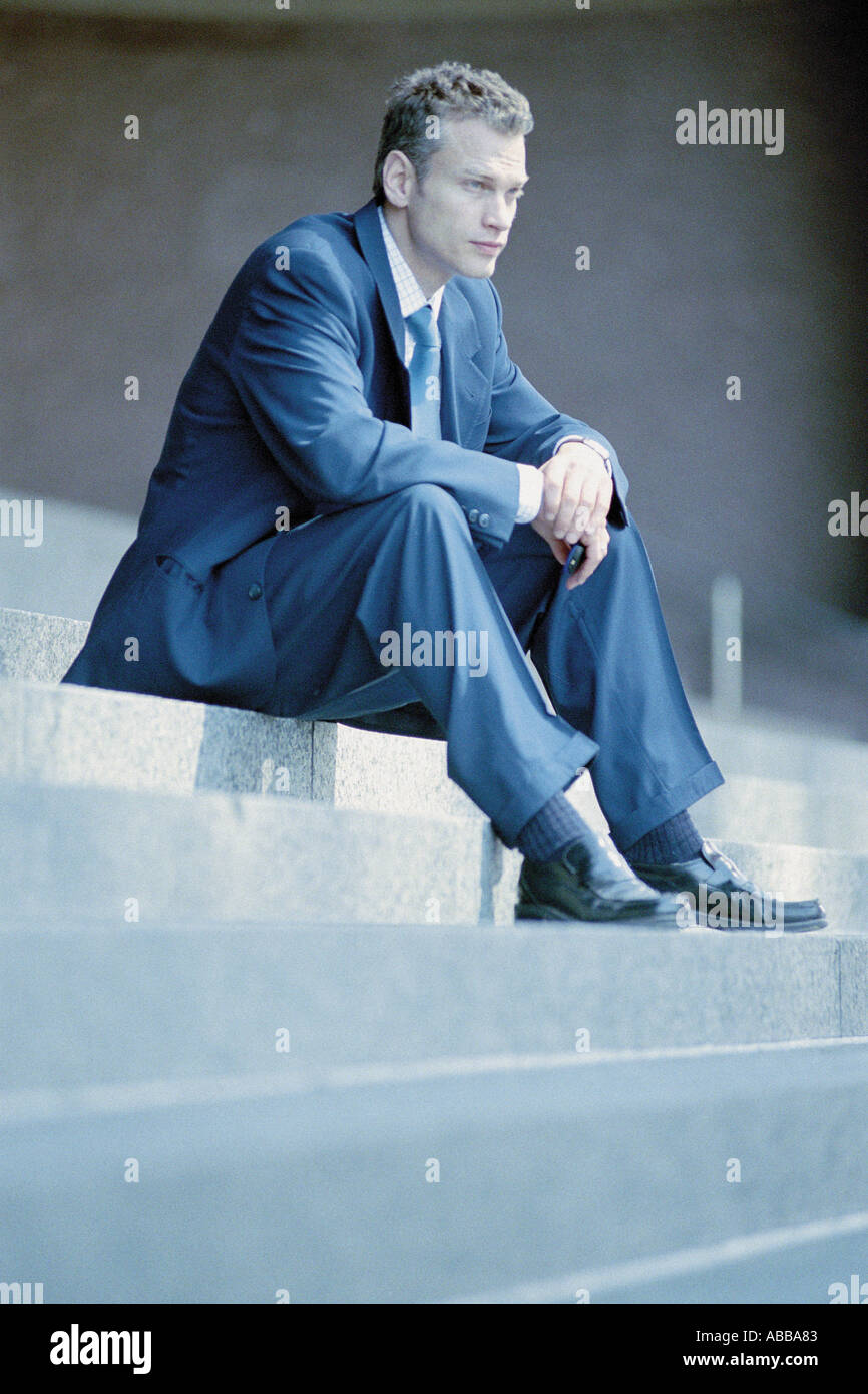 Businessman sitting on steps Stock Photo