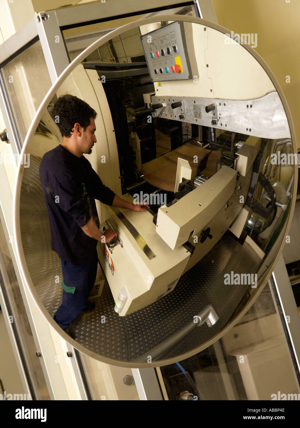 Round wide angle view safety mirror in manufactoring plant with man working visible factory industry industrial Stock Photo