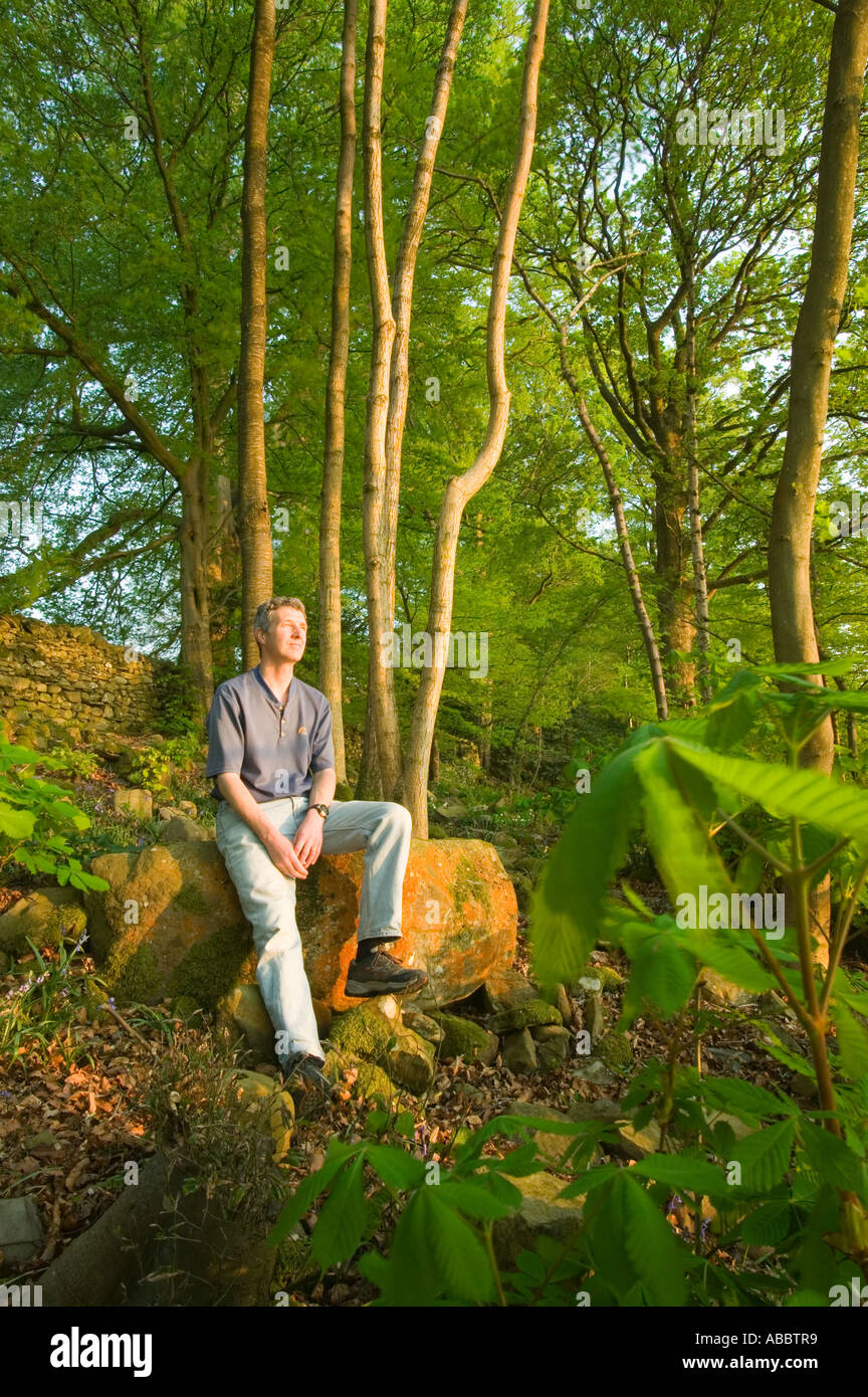 a man relaxing in  spring woodland on the shores of Lake windermere at Rayrigg, Cumbria, UK Stock Photo