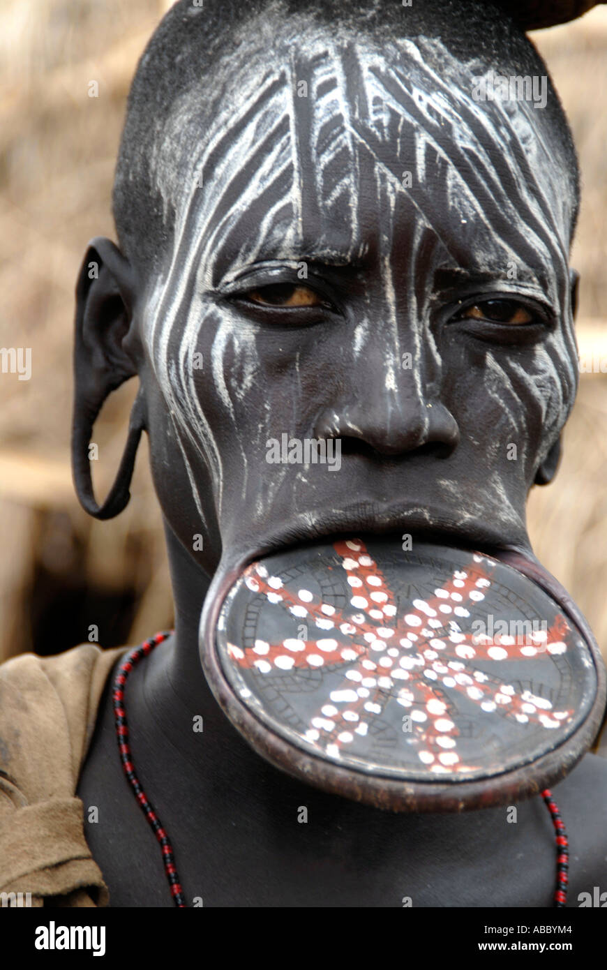 Portrait woman of the Mursi people wearing a big colourful lip plate and  white colour on her face Ethiopia Stock Photo - Alamy