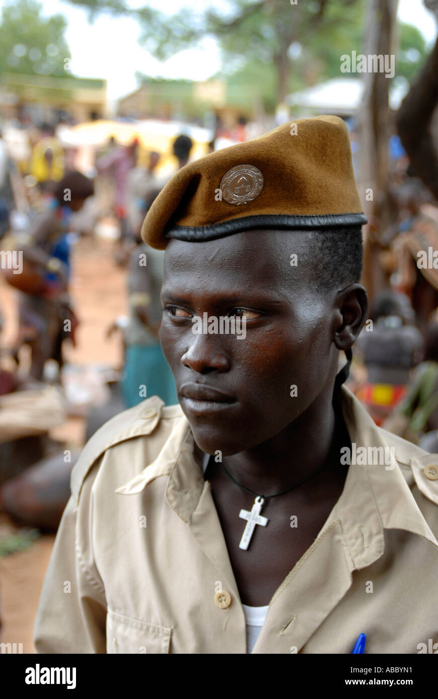 Portrait man of the Hamar people police officer wears necklace with a Christian cross ans observes vigilantly the market of Stock Photo