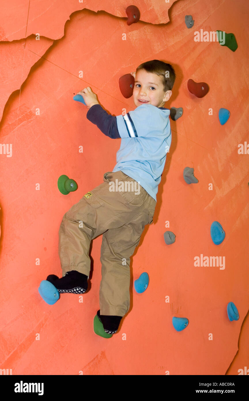 Children playing in an indoor playground at a climbing wall Stock Photo