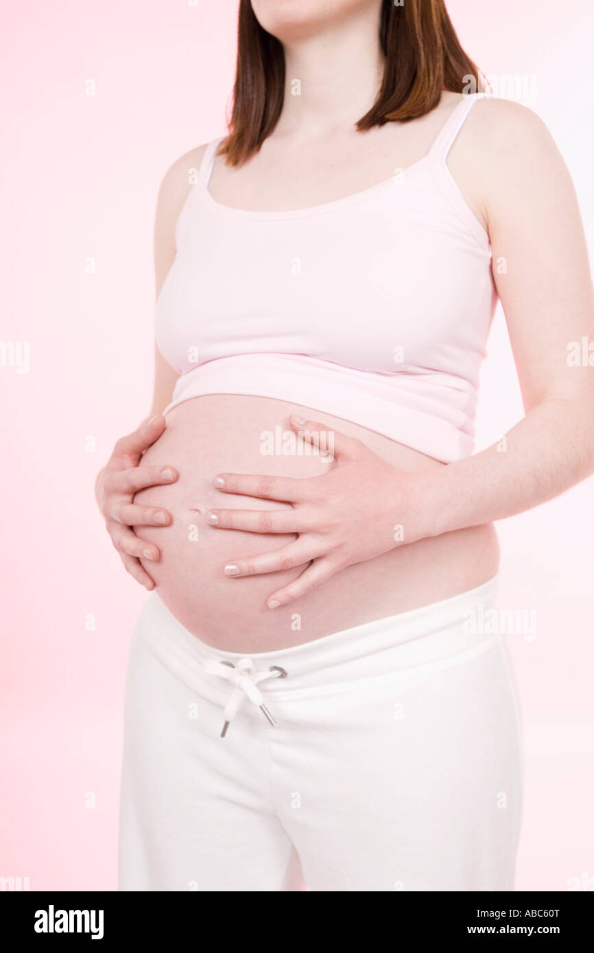 detail of pregnant young woman holding her belly Stock Photo - Alamy