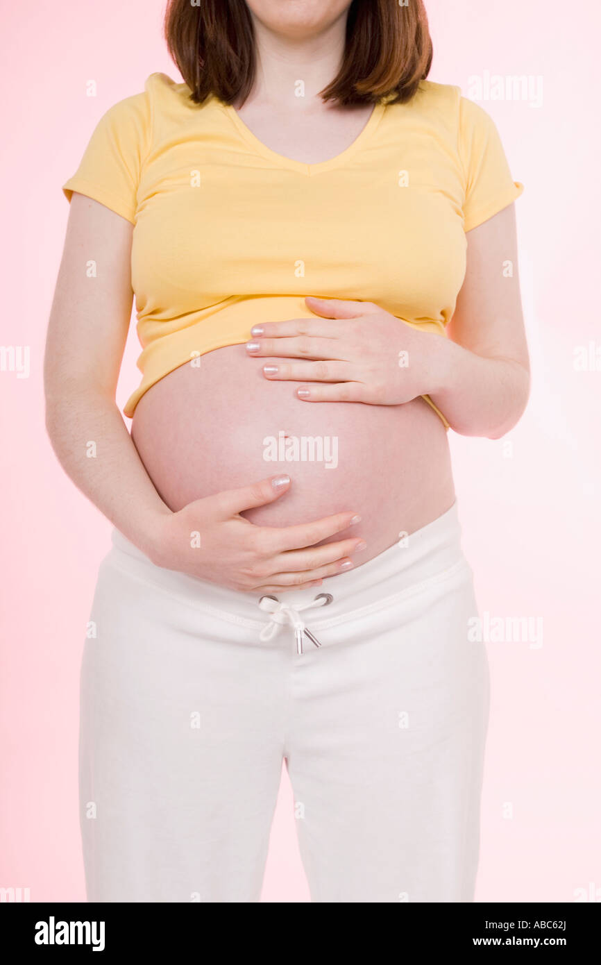 detail of pregnant young woman holding her belly Stock Photo - Alamy