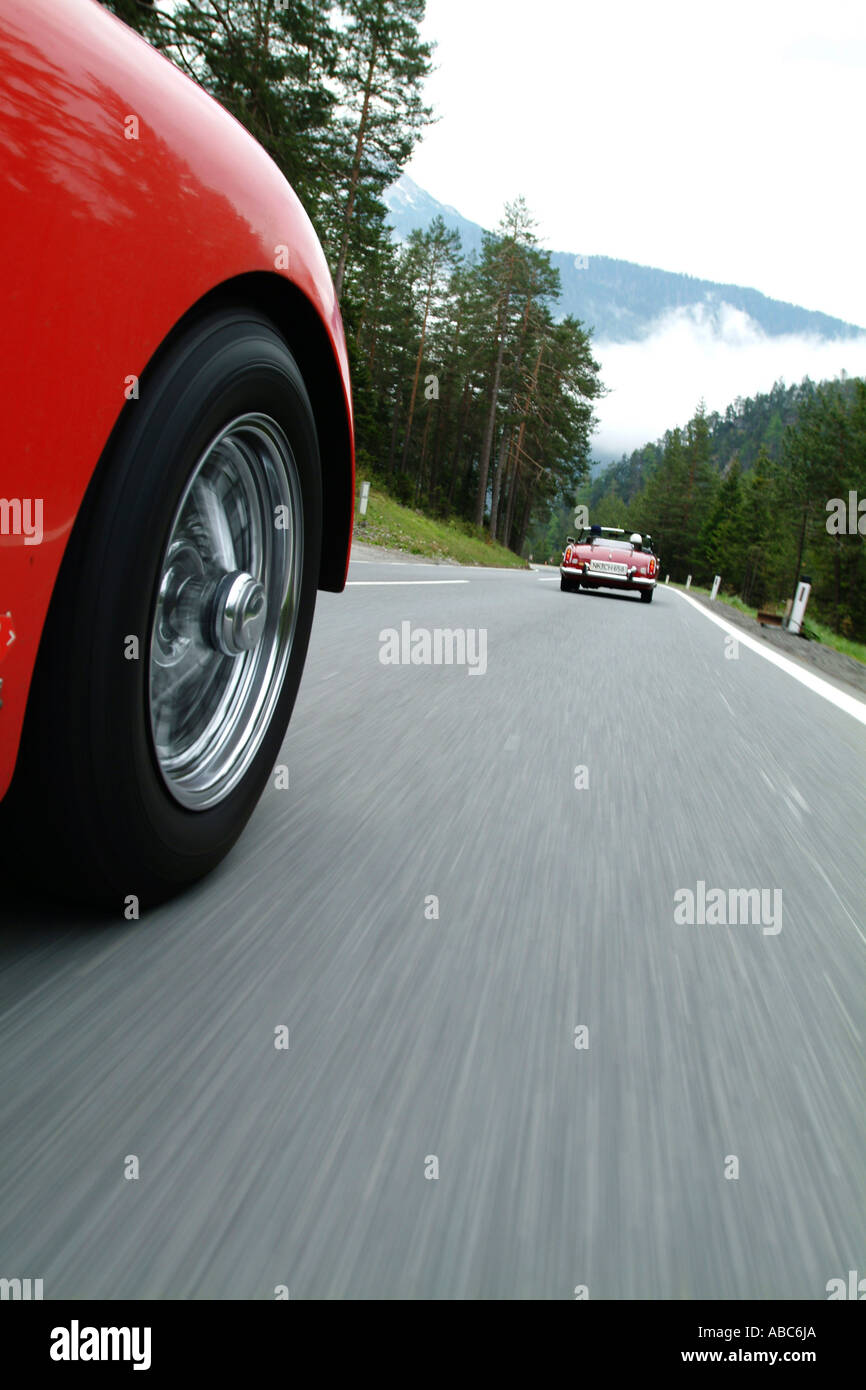 Red TR 3 driving behind a red vintage car Stock Photo