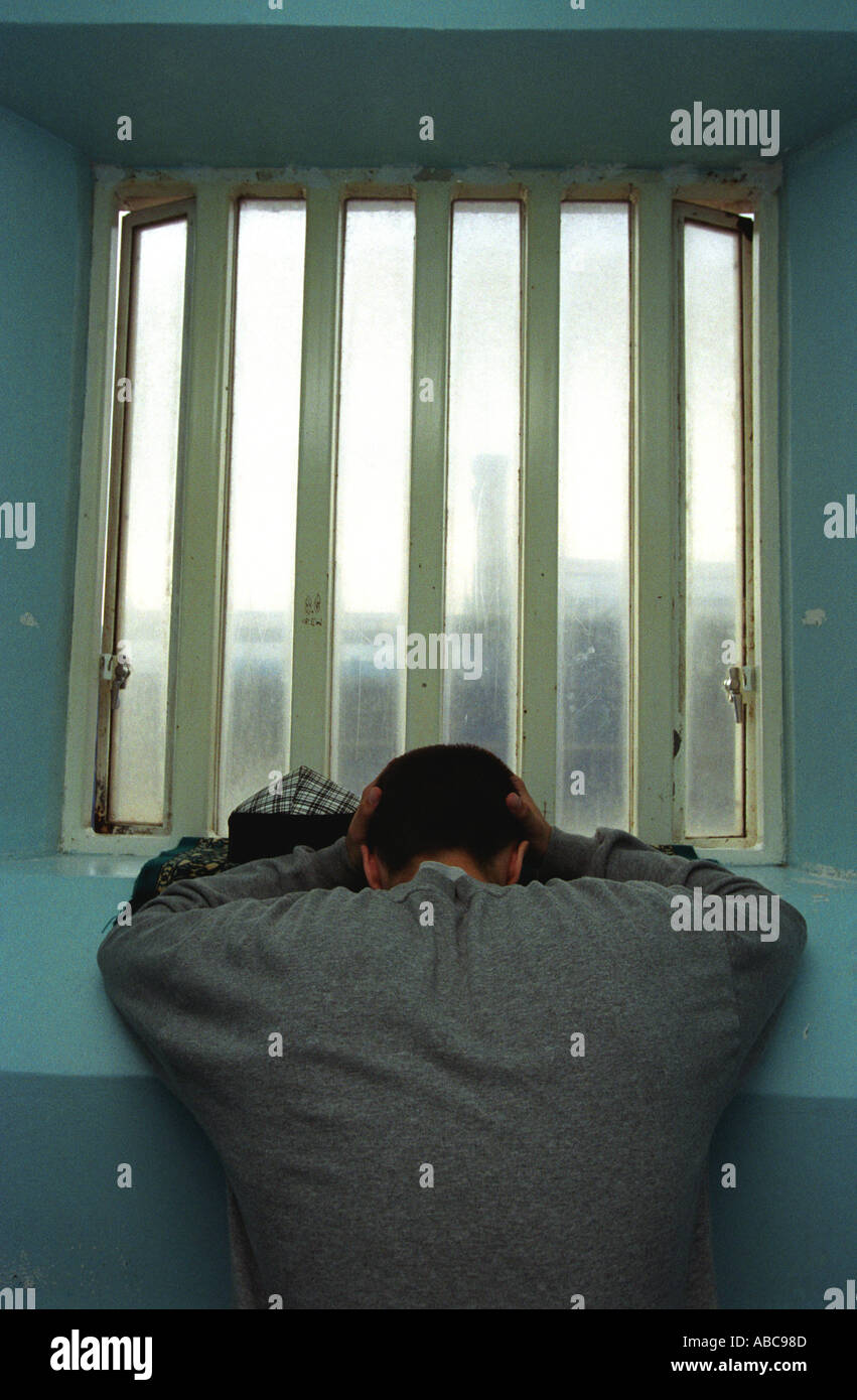 Young inmate looking depressed in prison cell, Portland Young Offenders Institution (YOI), Portland, Dorset, United Kingdom. Stock Photo