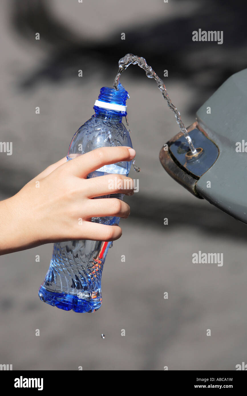 hand filling up water in a plastic bottle at a public spring fresh