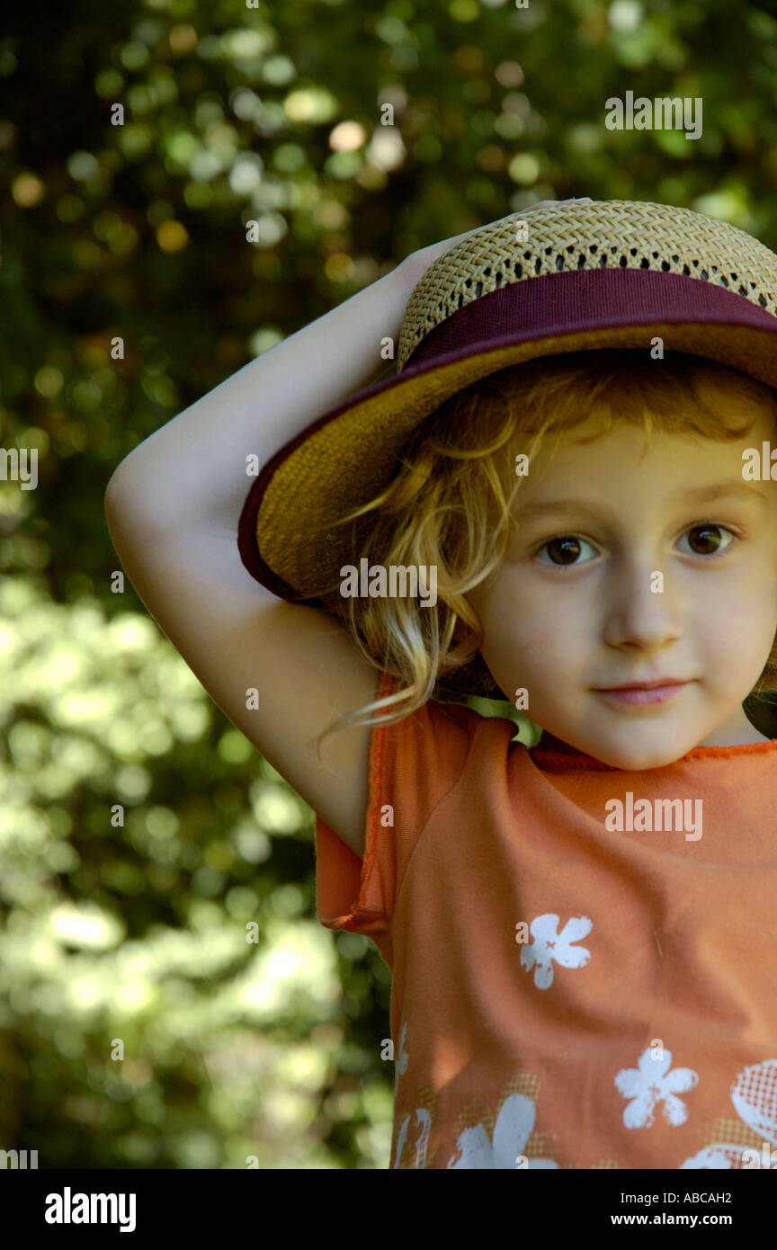 Portrait of a smiling little girl wearing a straw hat Stock Photo - Alamy