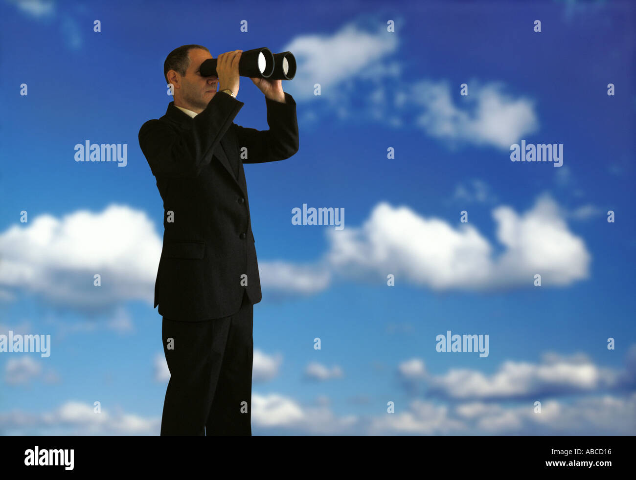 man in suit looking through binoculars Stock Photo