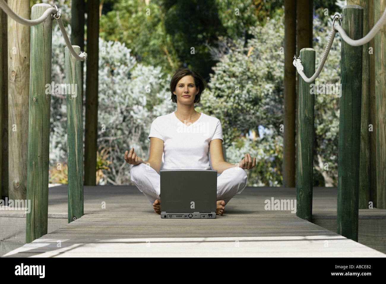 Woman with computer doing yoga Stock Photo